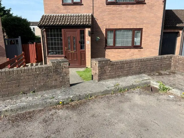 Brick boundary wall before professional cleaning in Bristol with algae and weather staining