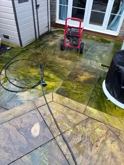 Patio covered in green algae before professional patio cleaning in Bristol