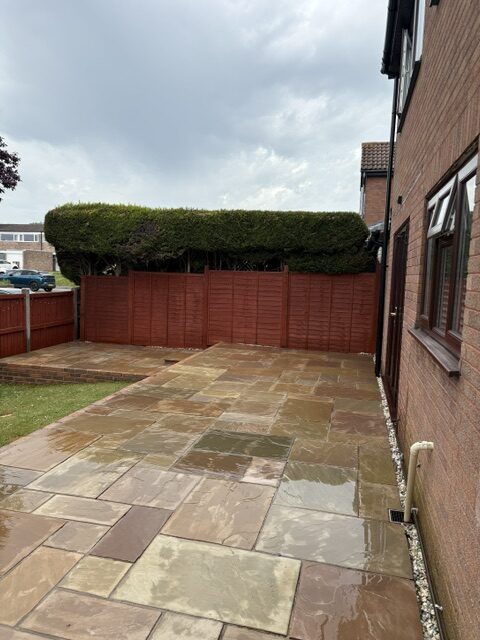 Patio paving slabs after professional pressure washing, showing the cleaner surface with moss and algae removed.